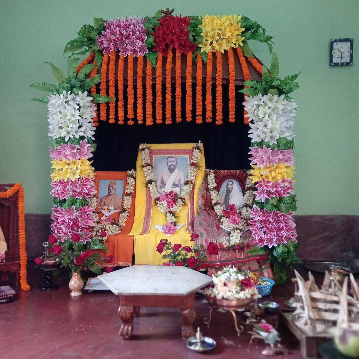 The ashram altar with images of Swami Vivekananda, Sri Ramakrishna and Holy Mother Sarada Devi, dressed with flowers